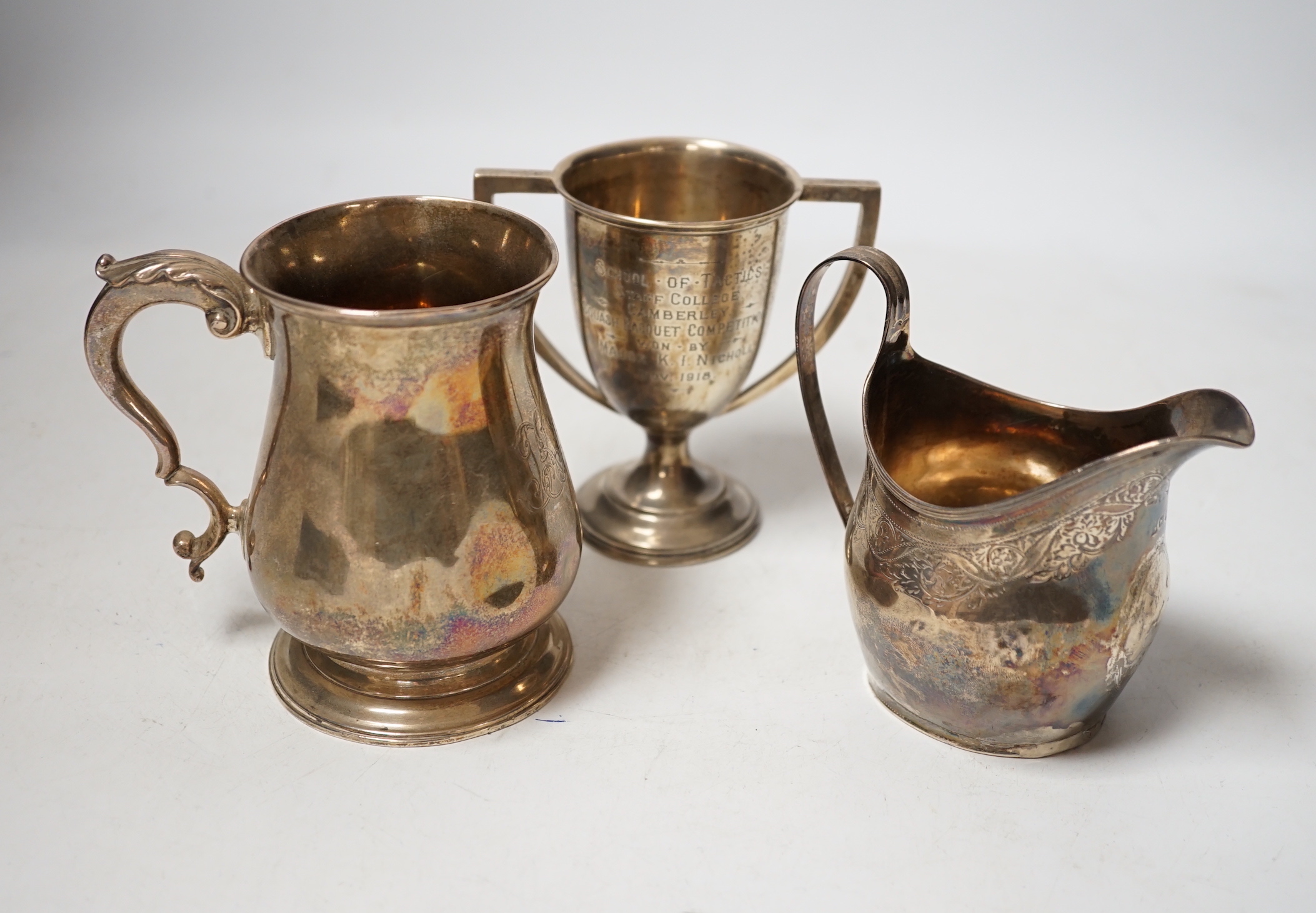 A George III silver cream jug, London, 1806, a George III silver half pint baluster mug, London, 1769 and a later silver two handled trophy cup, 13.7oz.